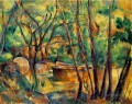 Piedra de molino y cisterna bajo los árboles Bosque de Paul Cezanne